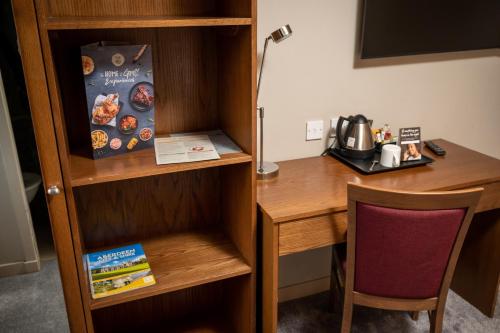 a desk in a room with a table and a chair at Wellington Hotel by Greene King Inns in Aberdeen