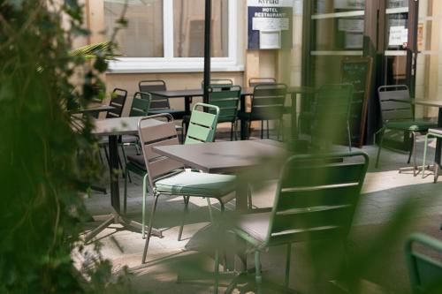 a row of tables and chairs in a restaurant at Kyriad Metz Centre - Restaurant Moze in Metz