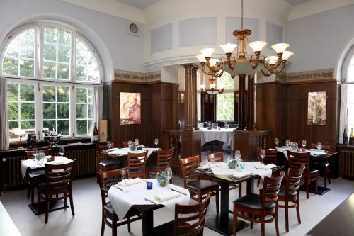 a restaurant with tables and chairs and a chandelier at Baumwipfelhaus in Annweiler am Trifels
