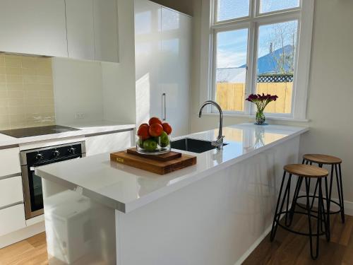 una cocina con una barra con un bol de fruta. en Luxurious Home Close to Beach en Dunedin