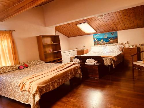 een slaapkamer met 2 bedden en een houten plafond bij PERLA Bianca DELLE 5 TERRE in La Spezia
