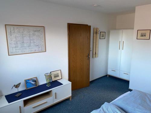 - une chambre avec un lit et une commode avec un sol bleu dans l'établissement Oberdeck, à Norderney