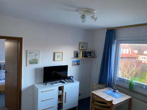 een kamer met een bureau, een televisie en een raam bij Oberdeck in Norderney