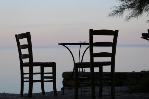 two chairs and a table and a table and chairs at Bastione Malvasia Hotel (ex New Malvasia) in Monemvasia