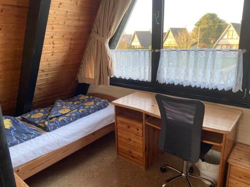 a bedroom with a desk and a bed and a desk chair at Ferienpark Fedderwardersiel in Fedderwarderdeich