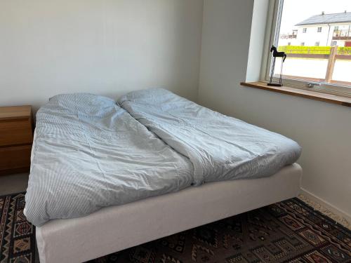 1 cama no hecha en un dormitorio con ventana en Hallands Equestrian Center, en Laholm