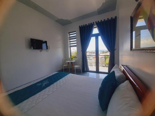 1 dormitorio con 1 cama grande con almohadas azules en Nhà Nghỉ Hà My en Quang Ngai
