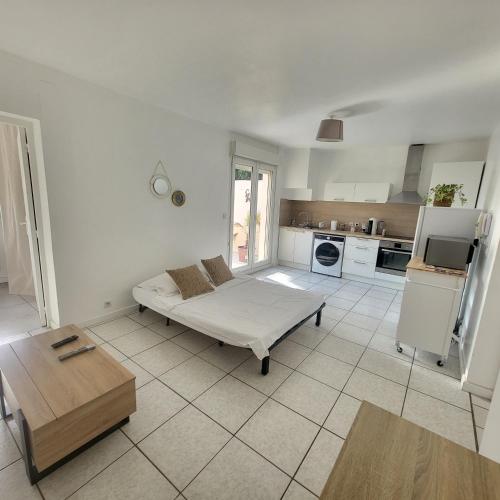 un salon avec un lit et une cuisine dans l'établissement Bel appartement avec jardin de 30m2 , climatisé avec parking et arrivée autonome, à Cabestany