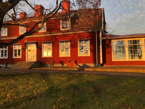 a red house with white windows on a street at Staby Gårdshotell in Högsby