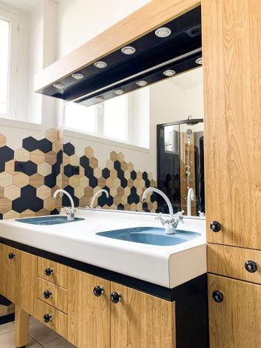 une salle de bain avec deux lavabos et un grand miroir dans l'établissement L'Estaminet Meublé de Tourisme Classé 2 étoiles, à Origny-Sainte-Benoîte