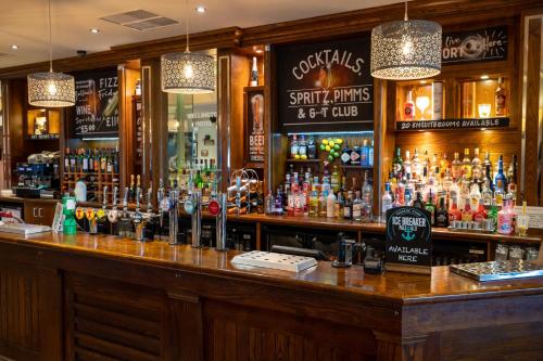 a bar with a lot of bottles of alcohol at Wellington Hotel by Greene King Inns in Aberdeen