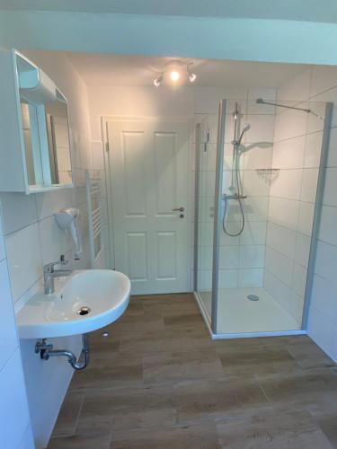 een badkamer met een wastafel en een douche bij Villa Pewsum in Krummhörn