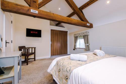 a bedroom with a bed and a table and a desk at Tranquil 1-bed barn in Beeston by 53 Degrees Property, ideal for Couples & Friends, Great Location - Sleeps 2 in Beeston