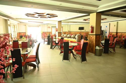 a dining room with tables and chairs in a restaurant at Rose Valley Hotel Naran in Nārān