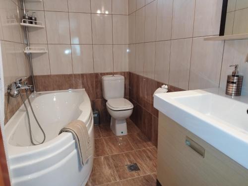 een badkamer met een bad, een toilet en een wastafel bij Voulas Guest House in Volos