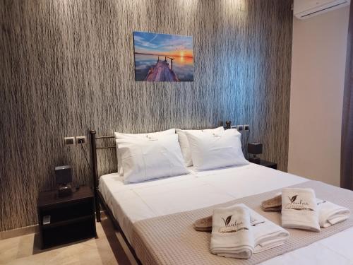 een slaapkamer met een bed met handdoeken erop bij Voulas Guest House in Volos