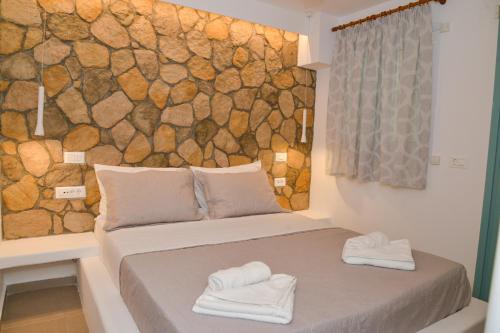 a room with a bed with two towels on it at Mylopetra Milos Suites in Tripiti