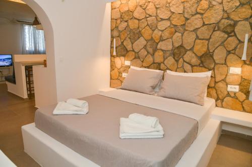 a bedroom with a bed with two towels on it at Mylopetra Milos Suites in Tripití
