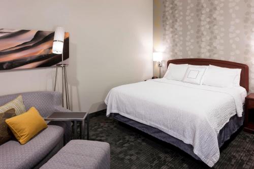 a hotel room with a bed and a couch at Courtyard by Marriott Wichita East in Wichita