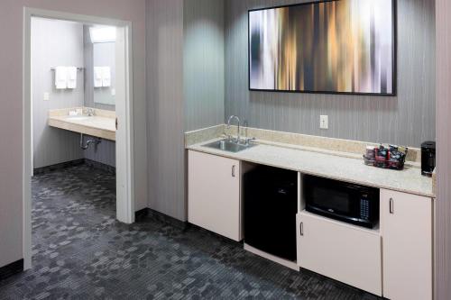 Un baño grande con fregadero y microondas. en Courtyard by Marriott Wichita East en Wichita