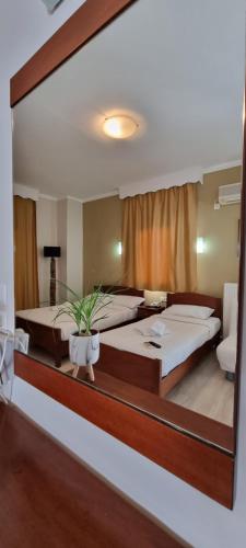 lustro odzwierciedlające sypialnię z 2 łóżkami w obiekcie Manolas w mieście Nei Pori