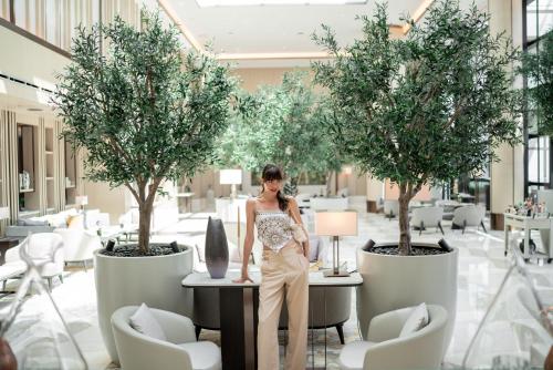 a woman standing at a table in a room with trees at Address Istanbul in Istanbul