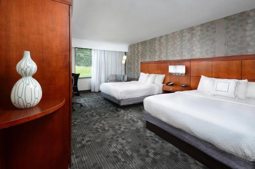 a hotel room with two beds and a vase at Courtyard Danville in Danville