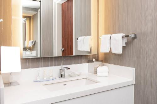 a bathroom with a white sink and a mirror at Courtyard by Marriott Bloomington in Bloomington