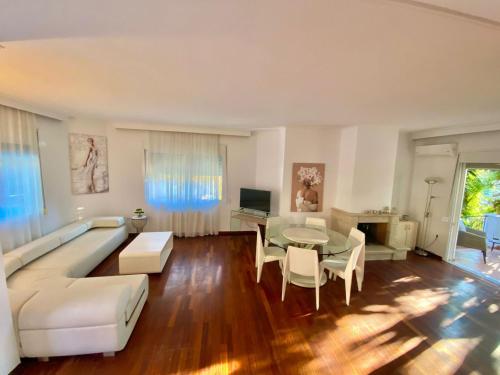 ein Wohnzimmer mit einem weißen Sofa und einem Tisch in der Unterkunft Corfu Villa Kanoni in Kanoni