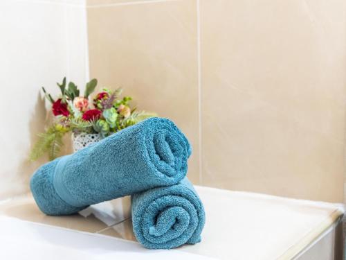 a blue towel sitting on a bathroom counter with a vase of flowers at 486 B Island Village Costa Adeje in Adeje