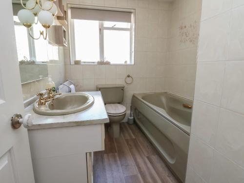 a bathroom with a sink and a tub and a toilet at Cock Bank Cottage in Wrexham