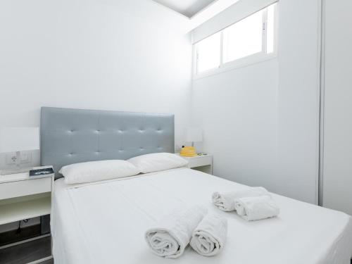 sypialnia z białym łóżkiem i ręcznikami w obiekcie 487 B Island Village Costa Adeje w Adeje