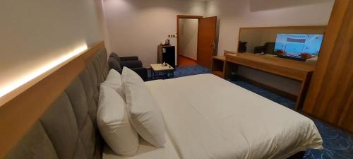 a hotel room with a bed and a television at Al Masem Serviced Apartments - Al Olaya - Exit 5 in Riyadh