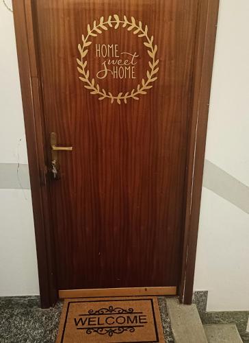 uma porta de madeira com um doce letreiro caseiro em HomeSweetHome Dervio em Dervio