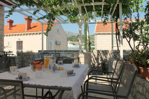 una mesa con un mantel blanco en el patio en Villa Jozefina, en Dubrovnik