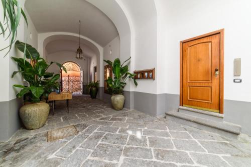 un corridoio con piante in vaso e una porta in legno di Estate4home - Henry House a Sorrento
