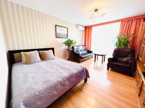 Comfy classic apartment in Trakai في تراكي: غرفة نوم بسرير وكرسي ونافذة