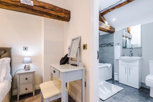 um quarto com um lavatório e uma secretária com um espelho em Beautiful 1-bed cottage in Beeston by 53 Degrees Property, ideal for Couples & Friends, Great Location - Sleeps 2 em Beeston