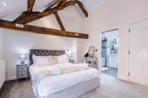 a bedroom with a large bed and a bathroom at Beautiful 1-bed cottage in Beeston by 53 Degrees Property, ideal for Couples & Friends, Great Location - Sleeps 2 in Beeston