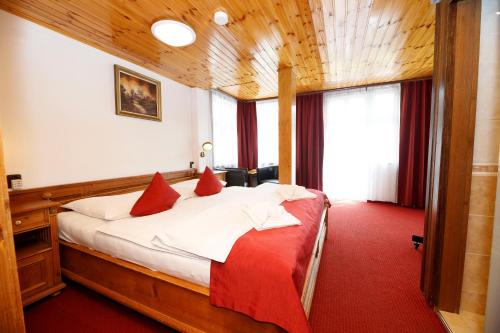 łóżko w pokoju z czerwonym dywanem w obiekcie Hotel Jelinek w Szpindlerowym Młynie