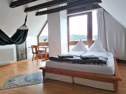 a bed in a room with a large window at Haus mit idyllischem Seeblick in Schalkenmehren