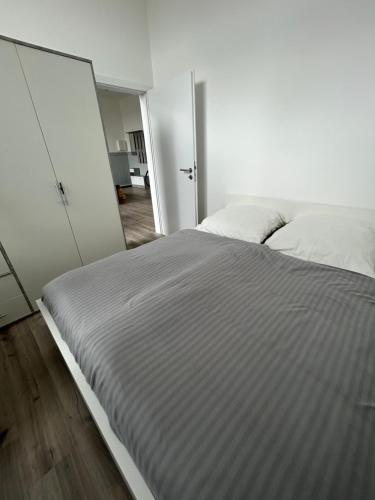 a white bedroom with a bed and a mirror at Alte Schule 1 in Schauenburg