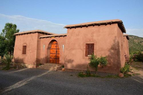 a small house with a door in a field at Camping Auberge Zebra in Ouzoud