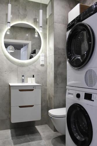 a bathroom with a washing machine and a sink at LuxApartmentWarszawa z bezpłatnym podziemnym parkingem in Warsaw