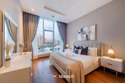a bedroom with a large bed and large windows at Manzil - Stylish 3BR in Palm w Private Beach & Sea View in Dubai