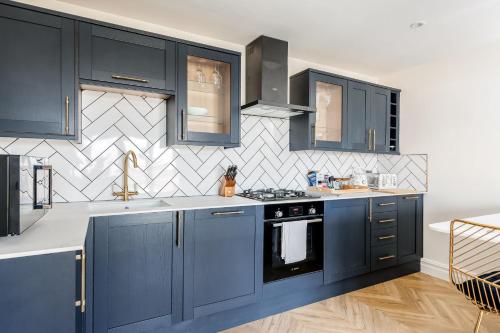 a kitchen with blue cabinets and a stove at Rockpools in Poole