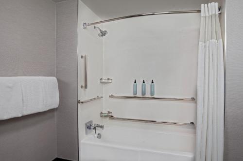 a white bathroom with a shower and a white tub at Courtyard by Marriott Boston Andover in Andover