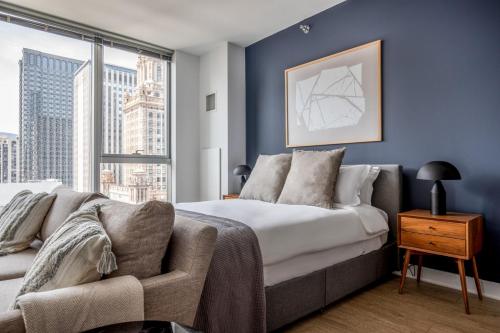 a bedroom with a bed and a couch and a window at Loop Studio w theater pool nr Millennium Park CHI-958 in Chicago