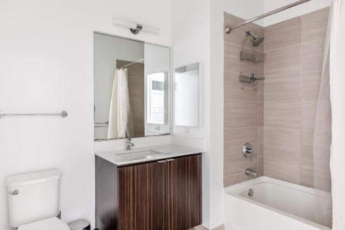 a bathroom with a sink and a toilet and a mirror at Loop Studio w theater pool nr Millennium Park CHI-958 in Chicago