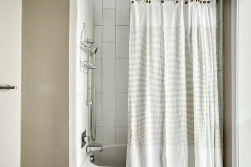 a shower with a white shower curtain in a bathroom at Shaw Studio w Gym WD Roof nr U St WDC-575 in Washington